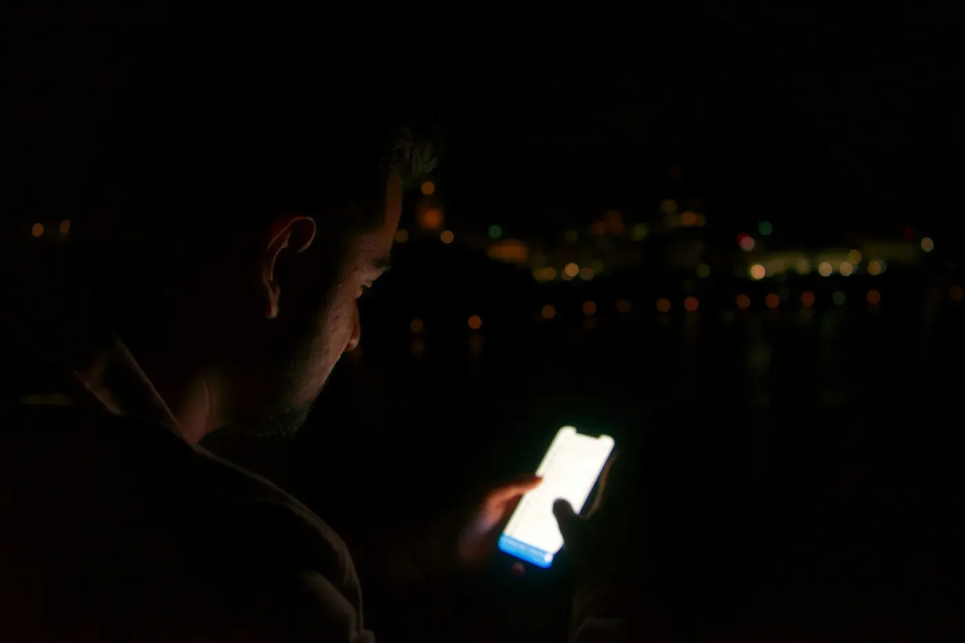 A person checking their phone at night
